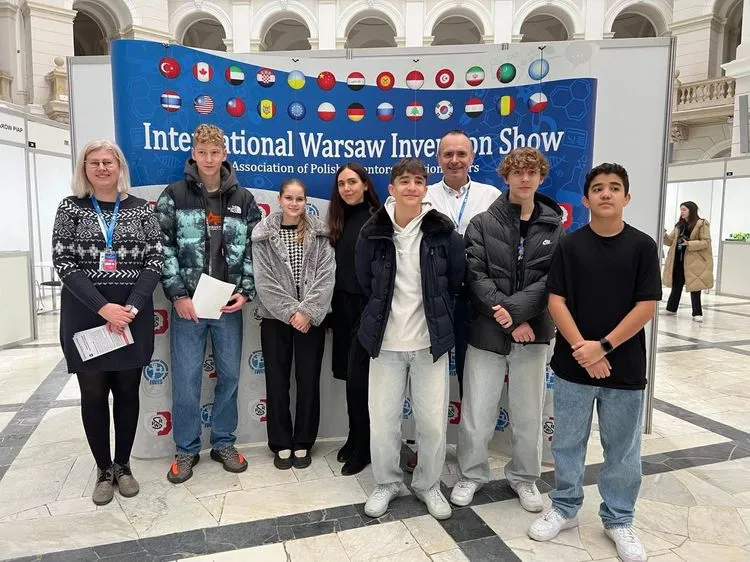 Ludzie stojący przed napisem International Warsaw Invention Show